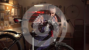Bicycle maintenance and repair concept. Male mechanic cleaning and oiling mountain bike with oil spray.