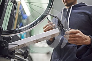 Bicycle maintenance service: man aligning a bike wheel using a truing stand