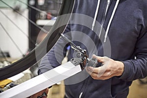 Bicycle maintenance service: person aligning a bike wheel using a truing stand