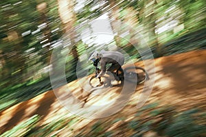 Bicycle, man and forest speed blur for workout outdoor in woods for healthy body. Mountain bike, nature and athlete