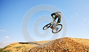 Bicycle, man and jump in air, dirt and outdoor for sports, race or adventure in summer, woods or nature. Extreme cycling
