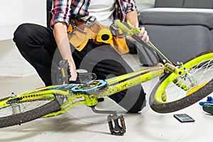 bicycle mechanic adjusting front derailleur mechanism on mountain bike