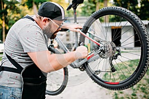 Bicycle mechanic adjusts back disk brakes