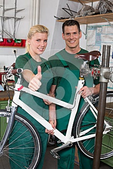 Bicycle mechanic and apprentice repairing a bike