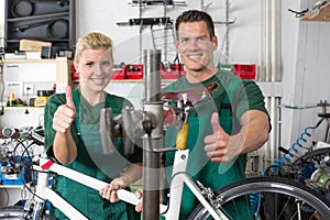 Bicycle mechanic and apprentice repairing a bike