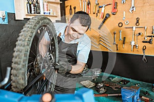 bicycle mechanic in aprons installing wheels and axles with copyspace