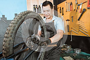 bicycle mechanic in aprons installing wheels while fixing problems