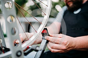 Bicycle mechanic hands repair wheel closeup