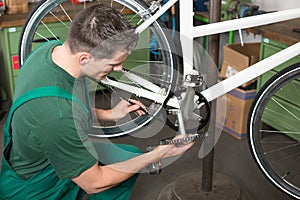 Bicycle mechanic repairing tooth belt in a workshop