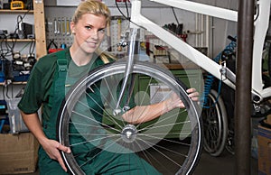 Bicycle mechanic repairing wheel on bike in a workshop