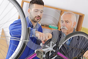 Bicycle mechanic and trainee working on bike