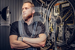 Bicycle mechanic in a workshop with bike parts and wheel on a background. photo