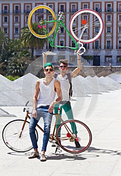 Bicycle, men and friends in a city street with freedom, holiday or vacation, pose and attitude on urban background. Bike