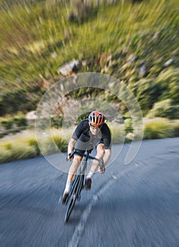 Bicycle, motion blur and man cycling fast in nature, mountain or adventure on trail, forest or valley path. Athlete