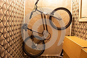 Bicycle mounted on the ceiling in a small residential apartment with limited space, bicycle storage at home