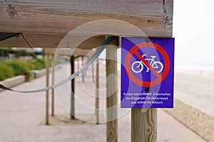 Bicycle no parking bike means in french ne pas accrocher velos aux tuteurs et arbres text and sign Do not park bicycle in trees photo