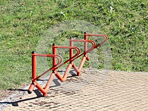 Bicycle park. Metal orange handrails for parking bicycles. A device to make life easier for cyclists. Facilities for the city`s ec