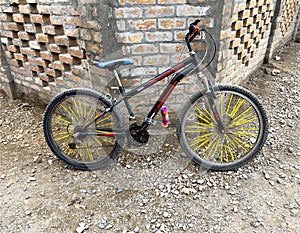 A bicycle parked at a bricks wall. Closeup photo