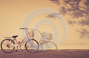 Bicycle parked at morning time beside the wall and shadow with a