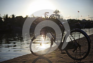 Bicycle parked by the river at the sunset in Europ photo