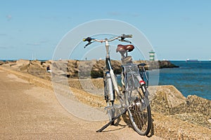 Bicycle parked on Scheveningen harbour entance wall photo