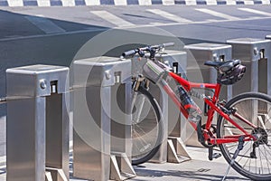 A bicycle parked between spaces of automatic vending bicycle parking machines on sidewalk of city street, unsafe parking concept