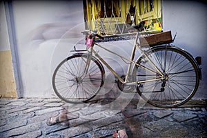 Bicycle parked in the street, silhouette blurred