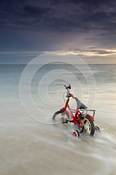 Bicycle parking on beautiful beach on tropical paradise island with sunset in background.