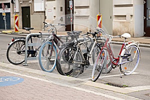 Bicycle parking on a city street. A lot of bikes are in a row