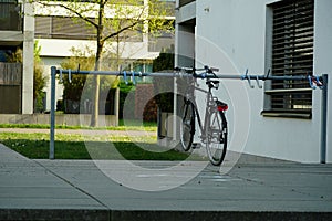 Bicycle parking place for visitors in front of a residential building with a parked bike as an example.