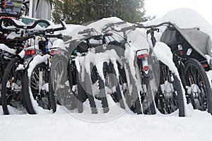 Row of bicycles covered with snow