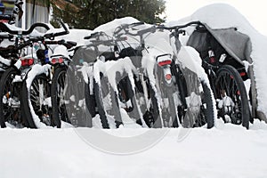 Row of bicycles covered with snow