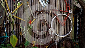 Bicycle parts hanging from a dry bamboo wall