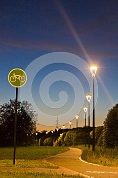 Bicycle path in evening park in summer