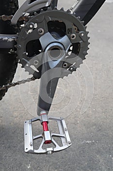 Bicycle pedal with a backdrop of asphalt