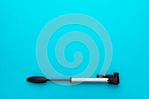Bicycle pump over turquoise blue background with copy space