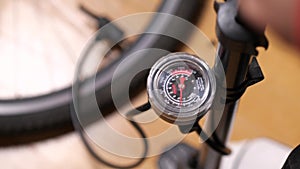 Bicycle pump. Pressure gauge needle moves around while pumping. Close-up.