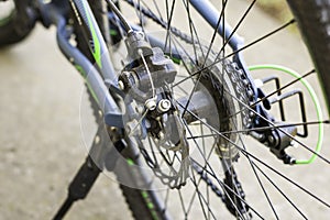 A bicycle rear wheel chain sprocket spokes disc brakes closeup