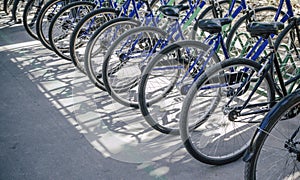 bicycle rent Public bicycles, sharing bikes saddle. Detail view of a bike wheel with more bicycles lined up. Bicycle rent. Closeu