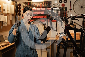 bicycle repair concept. Brunette woman using a digital tablet in a bicycle repair shop.