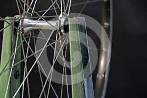 Bicycle repair. The front wheel is on a stand on a black background. Rim and spokes close-up. Mechanic levels the wheel in the