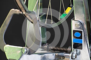 Bicycle repair. The front wheel is on a stand on a black background. Rim and spokes close-up. Mechanic levels the wheel in the