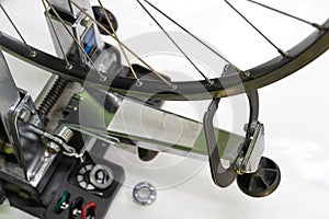 Bicycle repair. The front wheel is on a stand on a white background. Rim and spokes close-up. Mechanic levels the wheel in the