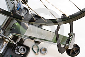Bicycle repair. The front wheel is on a stand on a white background. Rim and spokes close-up. Mechanic levels the wheel in the