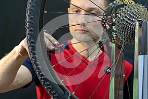 Bicycle repair. Rear wheel and tire closeup. Mechanic repairing spokes of the rear wheel of a mountain bike. Bike mechanic in the