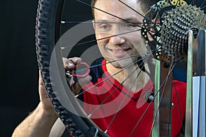 Bicycle repair. Rear wheel and tire closeup. Mechanic repairing spokes of the rear wheel of a mountain bike. Bike mechanic in the