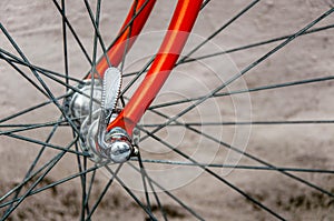 Bicycle repair. Wheel and shiny axle of chrome steel of an old road bike closeup. Retro bike. Red iron fork. Quick Release