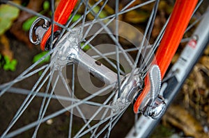 Bicycle repair. Wheel and shiny axle of chrome steel of an old road bike closeup. Retro bike. Red iron fork. Quick Release