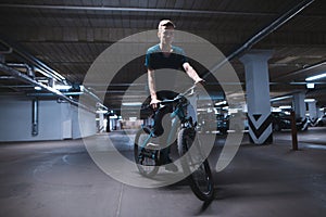 Bicycle rider rides on an underground parking lot. cyclist rides in an underground parking lot