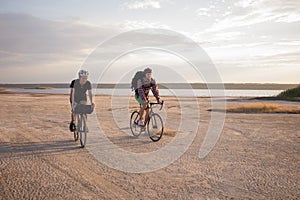 Bicycle riders ride outdoors on the fields near lake